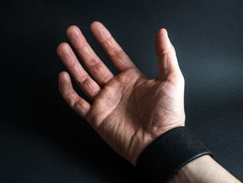 Cropped hand of person against black background
