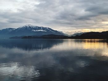 Scenic view of lake and snowcapped mountains against sky