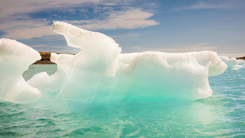 Low section of woman swimming in sea against sky