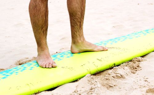 Low section of man standing on beach