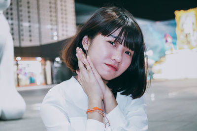 Portrait of young woman on street at night