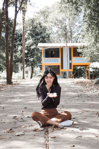 Portrait of young woman sitting outdoors