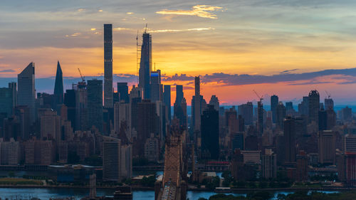 Aerial view of modern buildings against sky during sunset