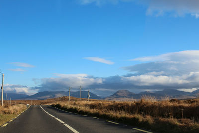 Road by landscape against sky