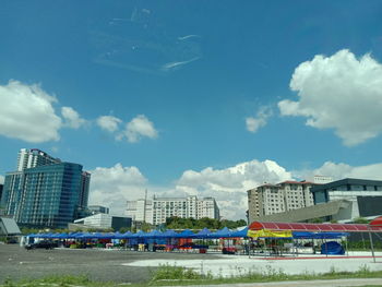 Airplane flying over buildings in city against sky