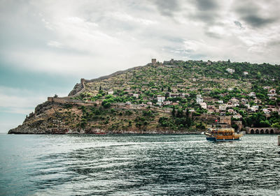 Scenic view of sea by alanya castle against cloudy sky