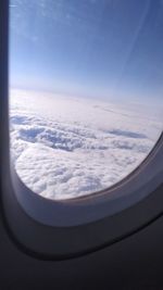 View of cloudy sky seen through airplane window