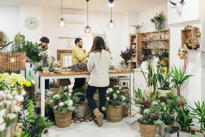 Shop owners arranging flowers standing at store