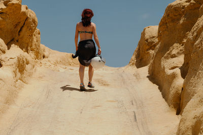 Rear view of woman standing on rock