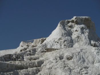 Low angle view of mountain against clear blue sky