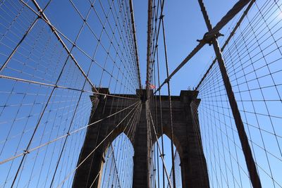 Low angle view of suspension bridge against blue sky