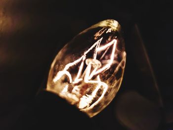 Close-up of illuminated lamp against black background