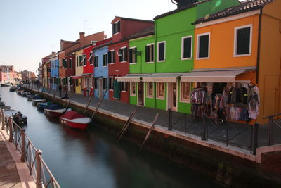 Boats in canal amidst buildings in city