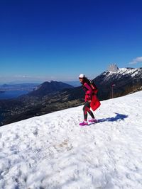 Full length of woman on snowcapped mountain against clear sky