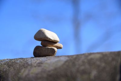 Close-up of stack of rock against blue sky