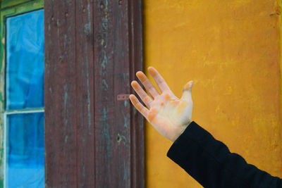 Close-up of cropped hand against wall