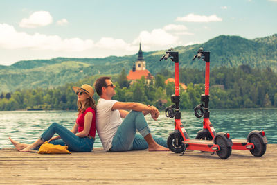 People sitting on motorcycle against sky