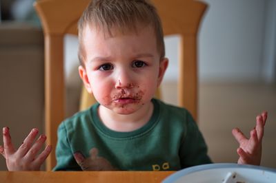 Cute little toddler smeared with chocolate around his mouth