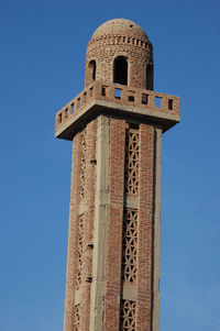 Low angle view of bell tower against clear blue sky