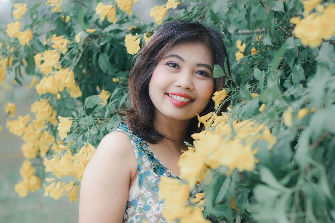 portrait, looking at camera, young adult, one person, young women, real people, front view, plant, leisure activity, lifestyles, women, flower, beautiful woman, beauty, flowering plant, smiling, adult, headshot, yellow, hair, hairstyle, flower head