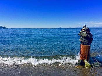 Man standing in sea against clear blue sky