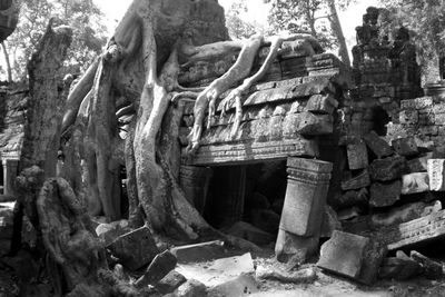 Low angle view of old statue against built structure