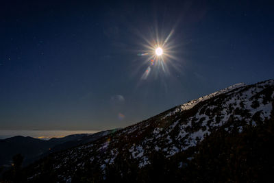 Low angle view of snowcapped mountains against sky