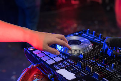 Close-up of woman playing music on audio equipment in nightclub