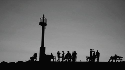 Silhouette people against clear sky