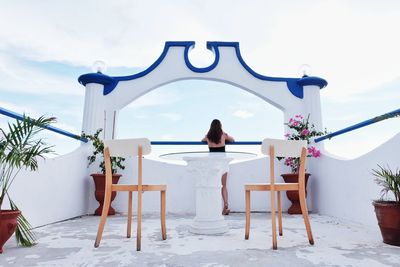 Rear view of woman sitting on chair