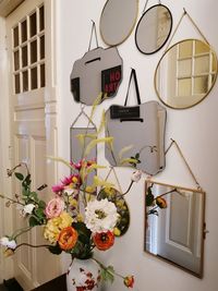 Flower vase on table against wall with mirrors at home