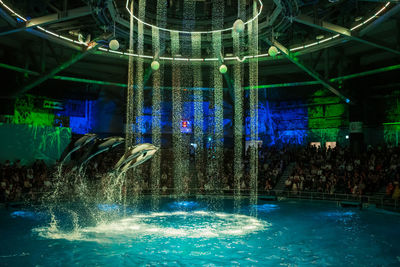 Illuminated fountain in swimming pool at night