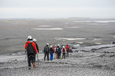 Rear view of people walking on landscape