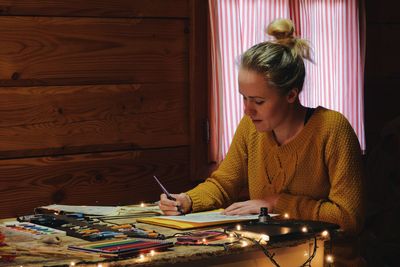 Woman sitting on table at home