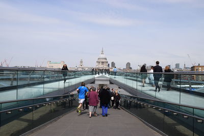 People on london millennium footbridge leading towards st pauls cathedral