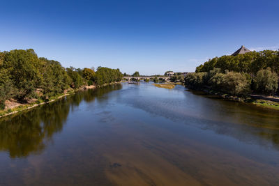 Scenic view of river against clear blue sky