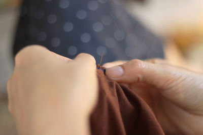 Close-up of woman stitching textile