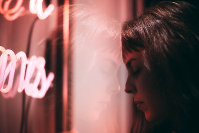 Reflection of thoughtful woman on window glass