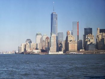 City at waterfront against blue sky