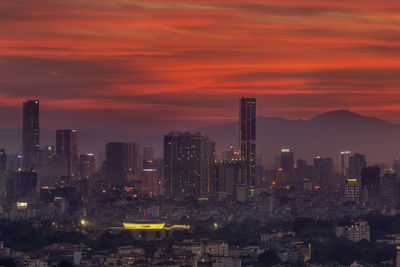 Illuminated cityscape against sky during sunset