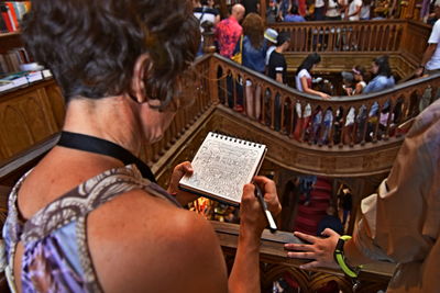 Rear view of people sitting in front of building