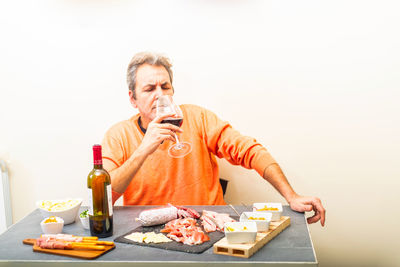 Midsection of man holding drink against white background