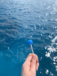 Close-up of hand holding ice cream in water