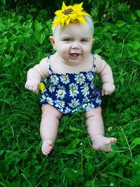 Full length portrait of baby girl sitting on field