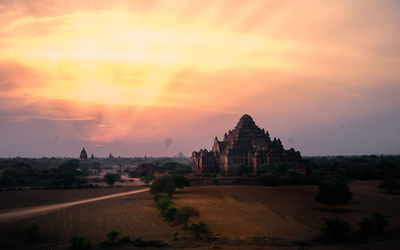 Built structure on landscape at sunset