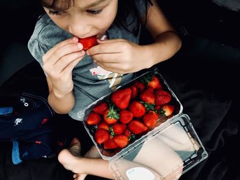 High angle view of woman holding strawberries