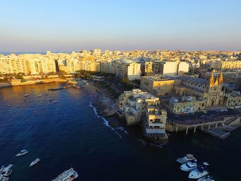 High angle view of cityscape by sea against sky
