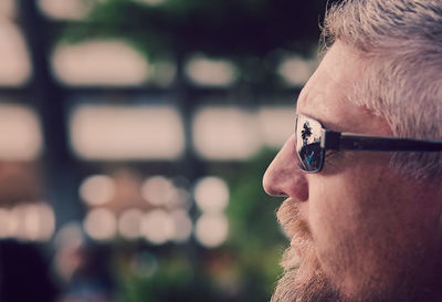 Close-up side view of man against blurred background