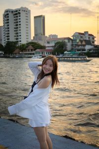 Portrait of young woman standing in sea
