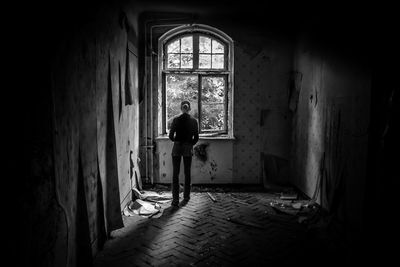 Rear view of man standing in abandoned building